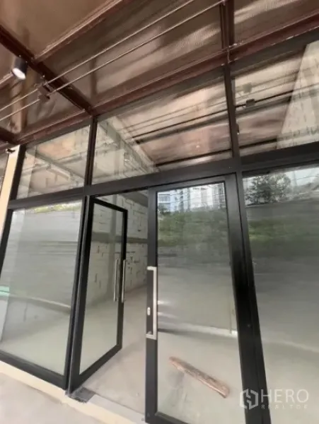 零售空间 出租 - 临街商铺，落地玻璃门面与黑色金属框，室内毛坯。