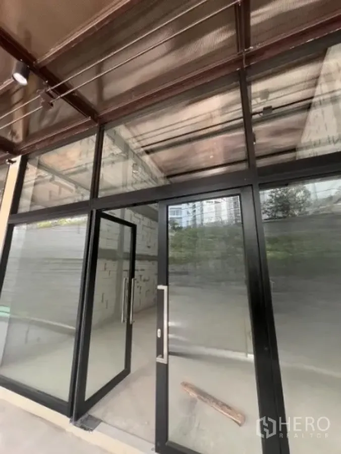 零售空间 出租 - 临街商铺，落地玻璃门面与黑色金属框，室内毛坯。