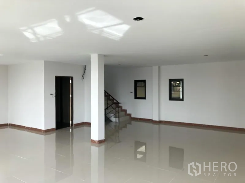 Factory for rent or sale in Bang Bua Thong, Nonthaburi - Open-plan office floor with glossy tiles, windows and stair access.