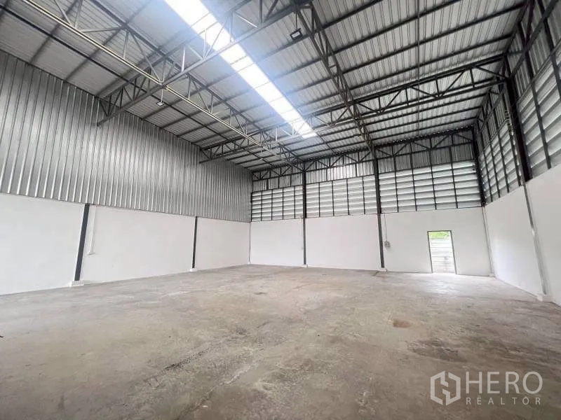 โกดัง for rent in Lam Luk Ka, Pathum Thani - ภายในโกดังหลังคาโครงเหล็กสูง มีช่องแสงและพื้นคอนกรีต
