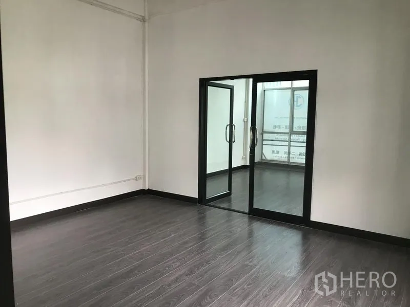 อาคารพาณิชย์ ให้เช่าในWatthana, Bangkok - พื้นที่ทำงานกว้าง พื้นไม้เข้ม พร้อมประตูกระจกบานเลื่อนไปยังห้องถัดไป