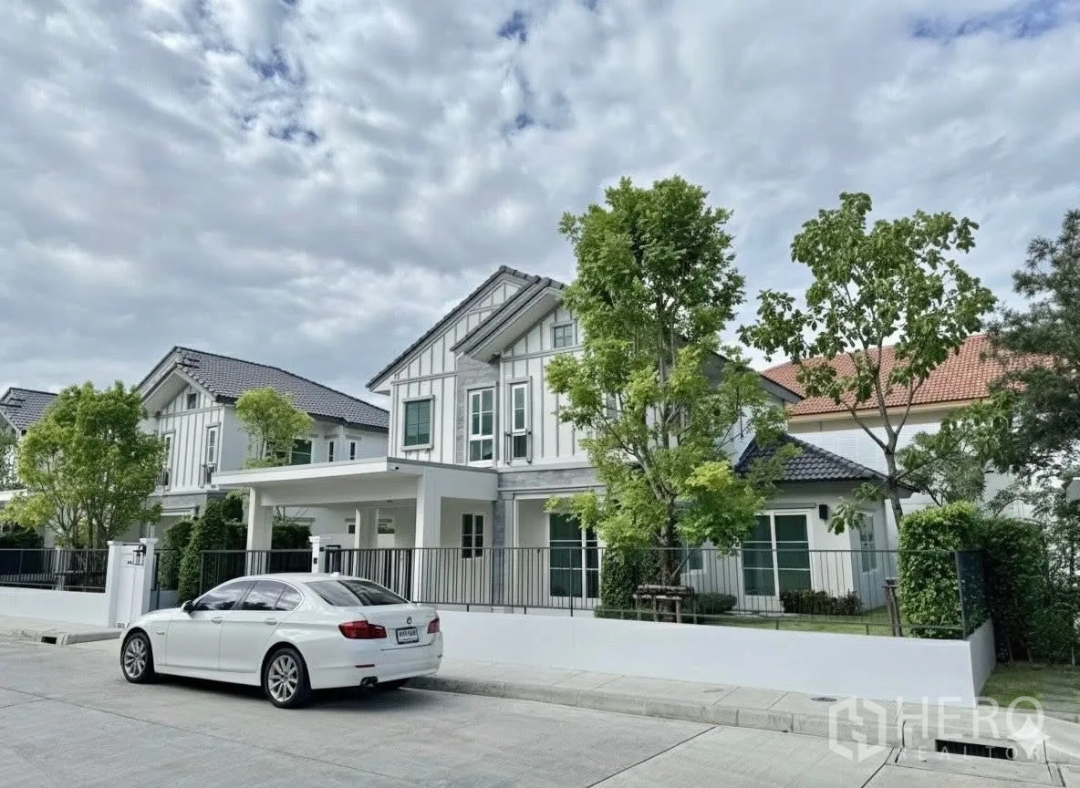 Detached House for rent in Bang Phli, Samut Prakan - Front streetscape showing modern two-storey detached houses with trees.