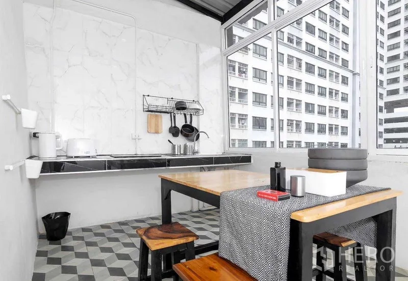 店屋 出售在Suan Luang, Bangkok - 带窗角落小厨房与餐桌，窗外为城市楼景。