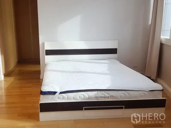 คอนโด ให้เช่าในKhlong Toei, Bangkok - ห้องนอนใหญ่รับแสงธรรมชาติ เตียงแพลตฟอร์มสีขาวและพื้นไม้