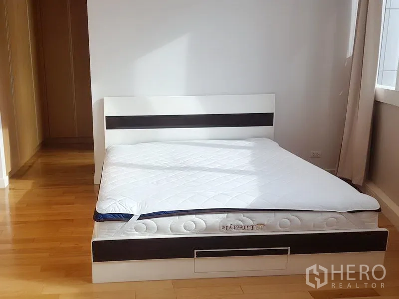 คอนโด ให้เช่าในKhlong Toei, Bangkok - ห้องนอนใหญ่รับแสงธรรมชาติ เตียงแพลตฟอร์มสีขาวและพื้นไม้