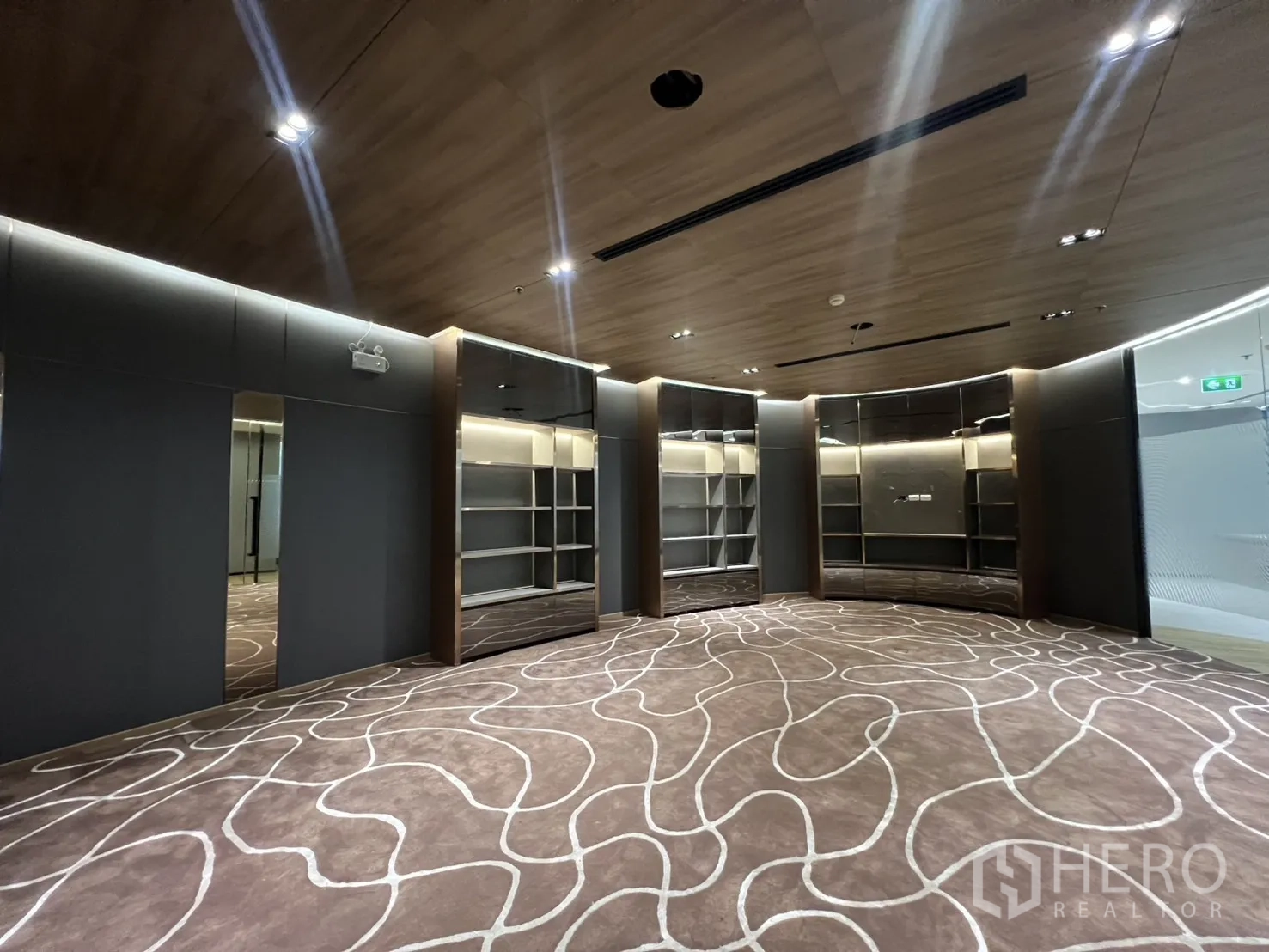 办公空间 出租在Huai Khwang, Bangkok - 宽敞的休闲/会议空间，内置展示柜与设计感地毯。