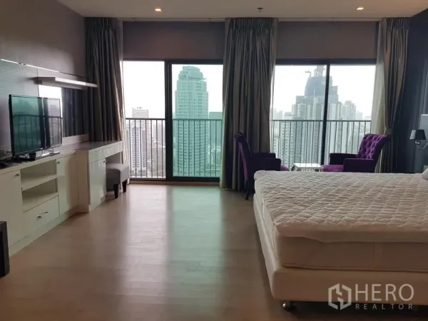 公寓 出租在Khlong Toei, Bangkok - 主卧落地窗与阳台，城市景观，配休闲椅与电视柜。