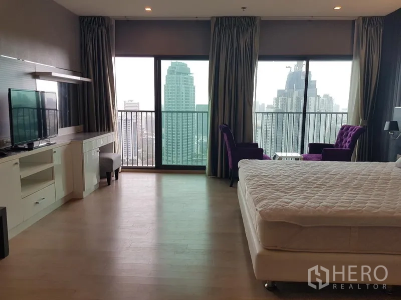 公寓 出租在Khlong Toei, Bangkok - 主卧落地窗与阳台，城市景观，配休闲椅与电视柜。