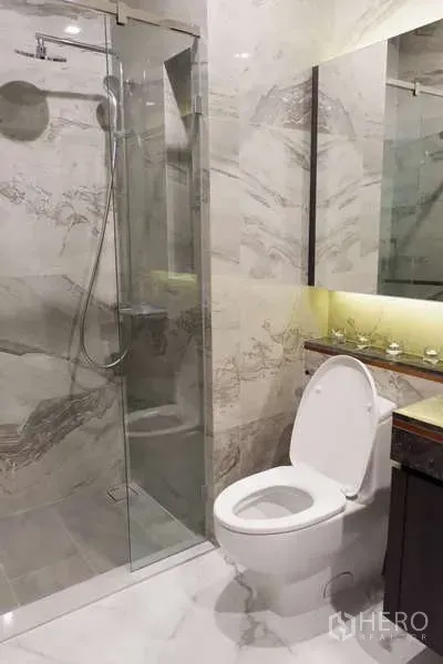 คอนโด ให้เช่า - ห้องน้ำสมัยใหม่พร้อมตู้กระจกกั้นอาบน้ำและผนังลายหินอ่อน