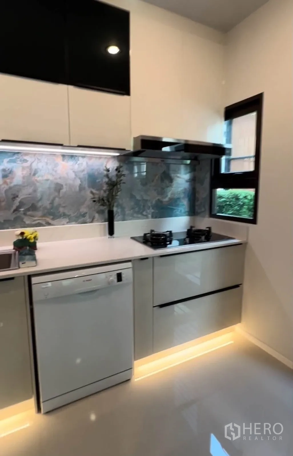 Detached House for rent in Bang Phli, Samut Prakan - Contemporary kitchen with gas hob, range hood, window, and dishwasher.