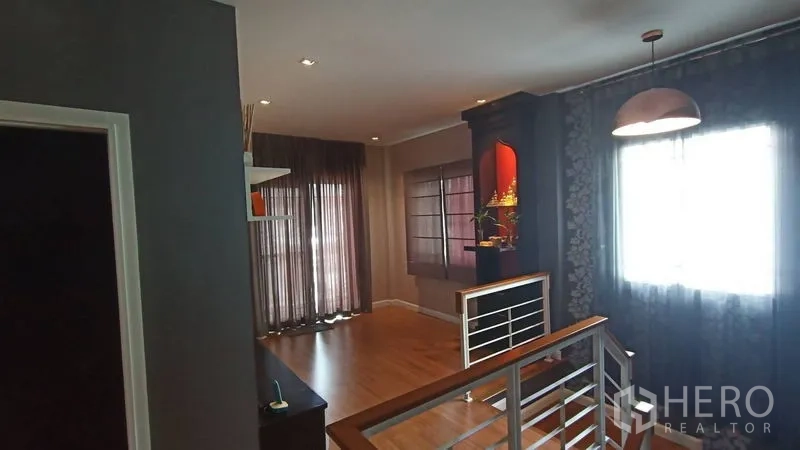 独立式住宅 出售在Prawet, Bangkok - 二楼走廊，吊灯、栏杆与落地窗帘。