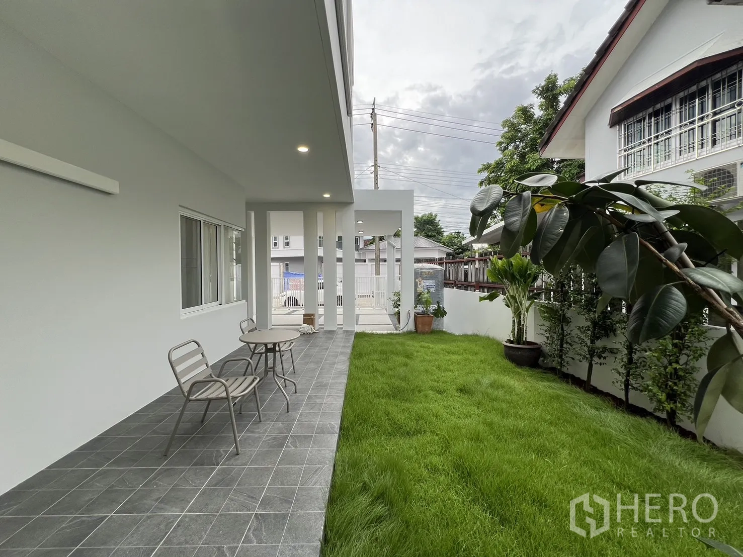 Detached House for rent in Saphan Sung, Bangkok - Long backyard lawn with privacy hedge and tiled patio.