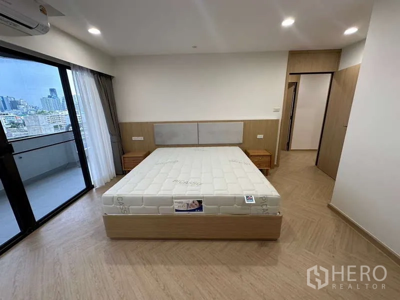 คอนโด ให้เช่าในWatthana, Bangkok - ห้องนอนเปิดออกสู่ระเบียง พร้อมโต๊ะข้างเตียงและวิวเมืองพาโนรามา