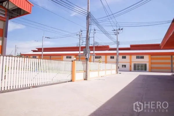 โรงงาน ขายในMueang Samut Prakan, Samut Prakan - ลานคอนกรีตรั้วรอบขอบชิดของโครงการอุตสาหกรรม มองเห็นอาคารโรงงานสีเดียวกัน