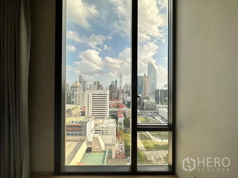 Condominium for rent in Pathum Wan, Bangkok - High-rise city skyline view from the condominium window on a clear day.