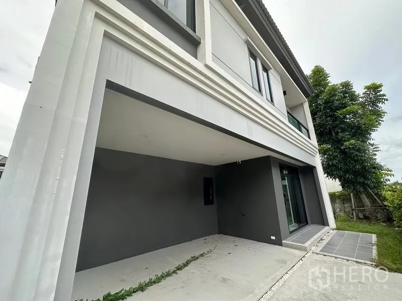 Detached House for sale in Khlong Sam Wa, Bangkok - Covered two-car carport and side entry beneath the upper balcony