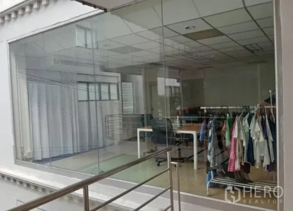 零售空间 出租在Khlong Toei, Bangkok - 玻璃门面零售铺，大片展示橱窗，开放式空间配桌椅与衣架