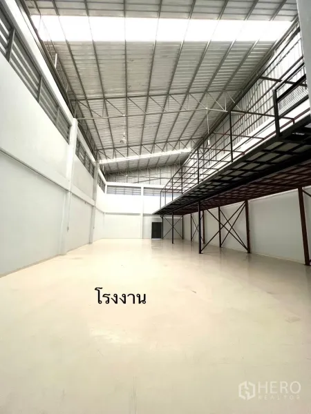 工厂 出租或出售在Mueang Samut Sakhon, Samut Sakhon - 明亮厂房内部，高屋顶并设夹层平台，适合货架存放。