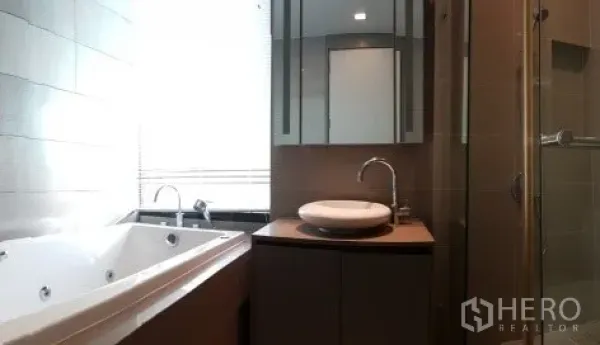 Condominium for rent in Bang Rak, Bangkok - Bathroom featuring a soaking tub, separate glass shower and a vanity with round basin.