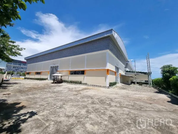 Factory for rent in Samut Prakan - Rear side of the factory with a spacious concrete yard and service doors.