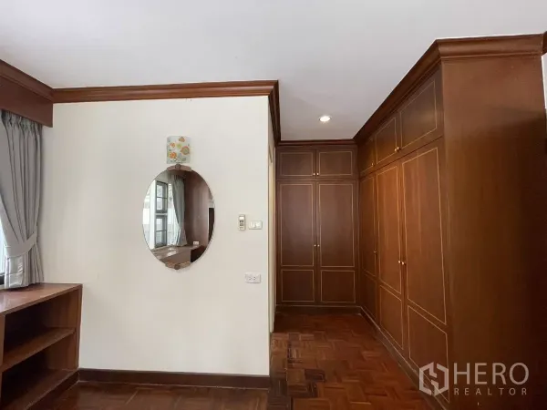 Detached House for rent in Chatuchak, Bangkok - Dressing area with wall mirror and rows of wooden wardrobes.