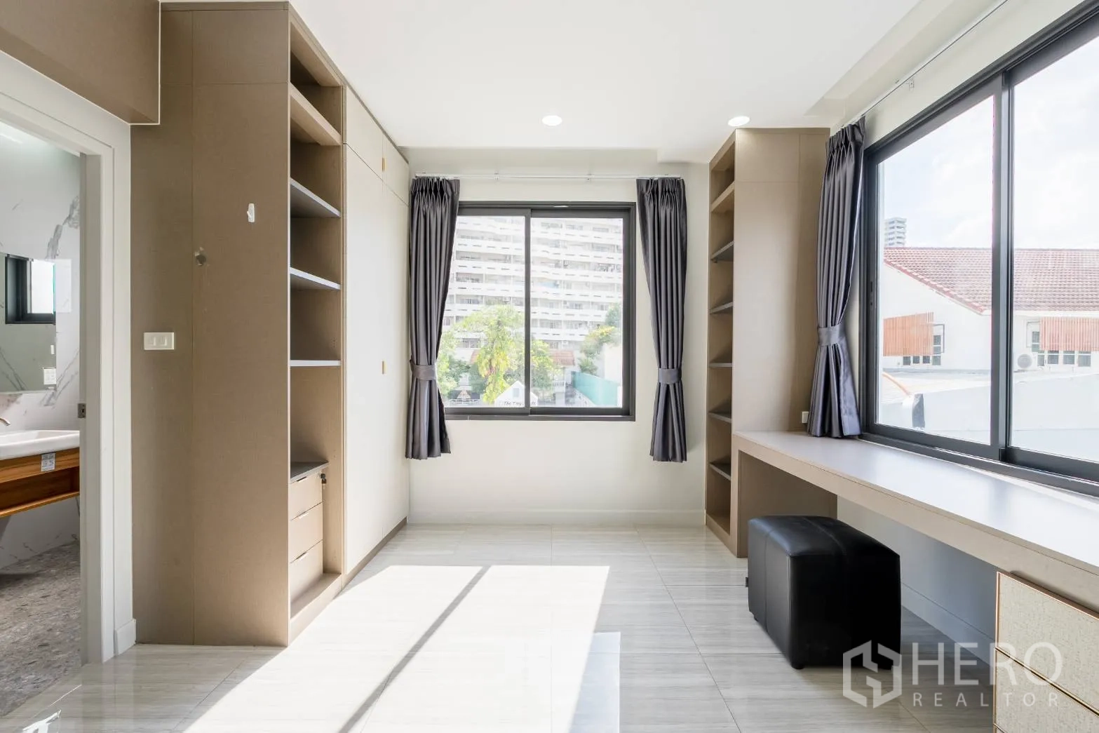 Home Office for rent in Khlong Toei, Bangkok - Sunlit multipurpose room with big windows, built-in shelves and long work desk.