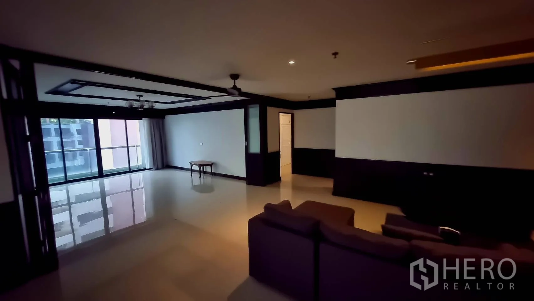 公寓 出租在Watthana, Bangkok - 转角起居区，落地推拉门通向阳台。