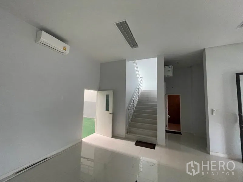 โรงงาน ให้เช่าในLam Luk Ka, Pathum Thani - โถงชั้นล่างพร้อมบันไดและประตูทางออกสู่พื้นที่บริการ