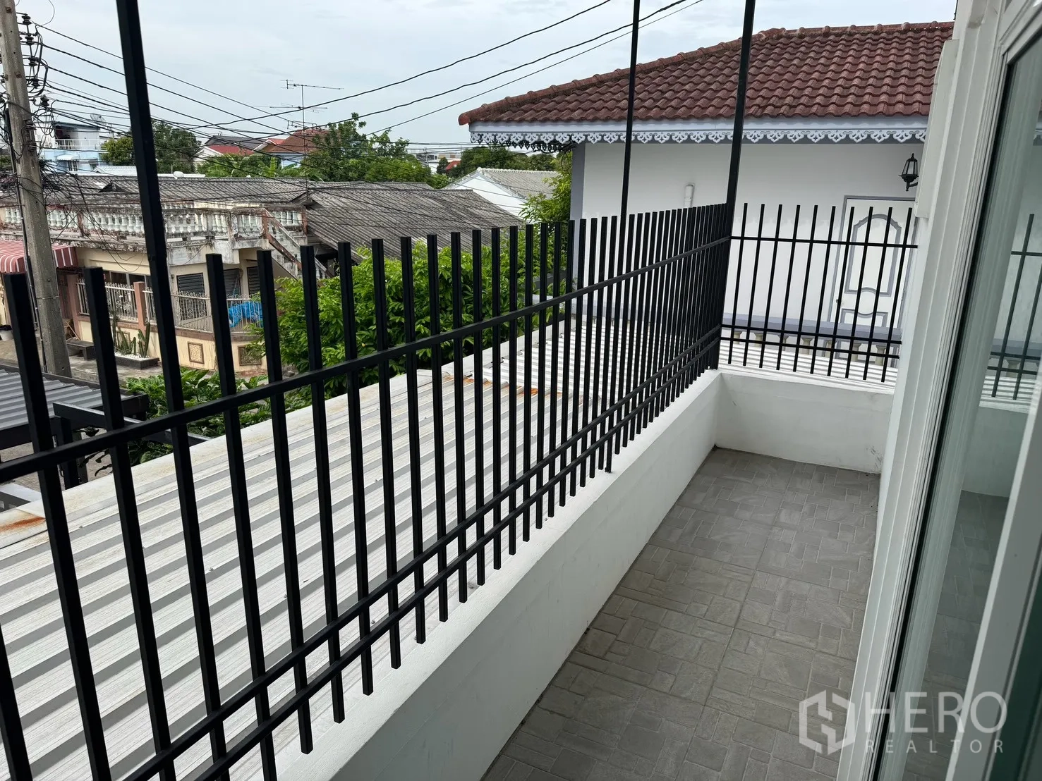 Detached House for rent in Saphan Sung, Bangkok - Narrow balcony with black metal railing overlooking neighboring rooftops.