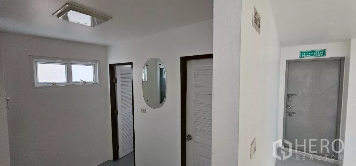 Office Space for rent in Bueng Kum, Bangkok - Corridor showing multiple restroom doors and a marked fire exit.