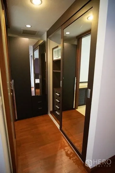 Townhouse for rent in Watthana, Bangkok - Walk-in closet with mirrored sliding doors and built-in storage.