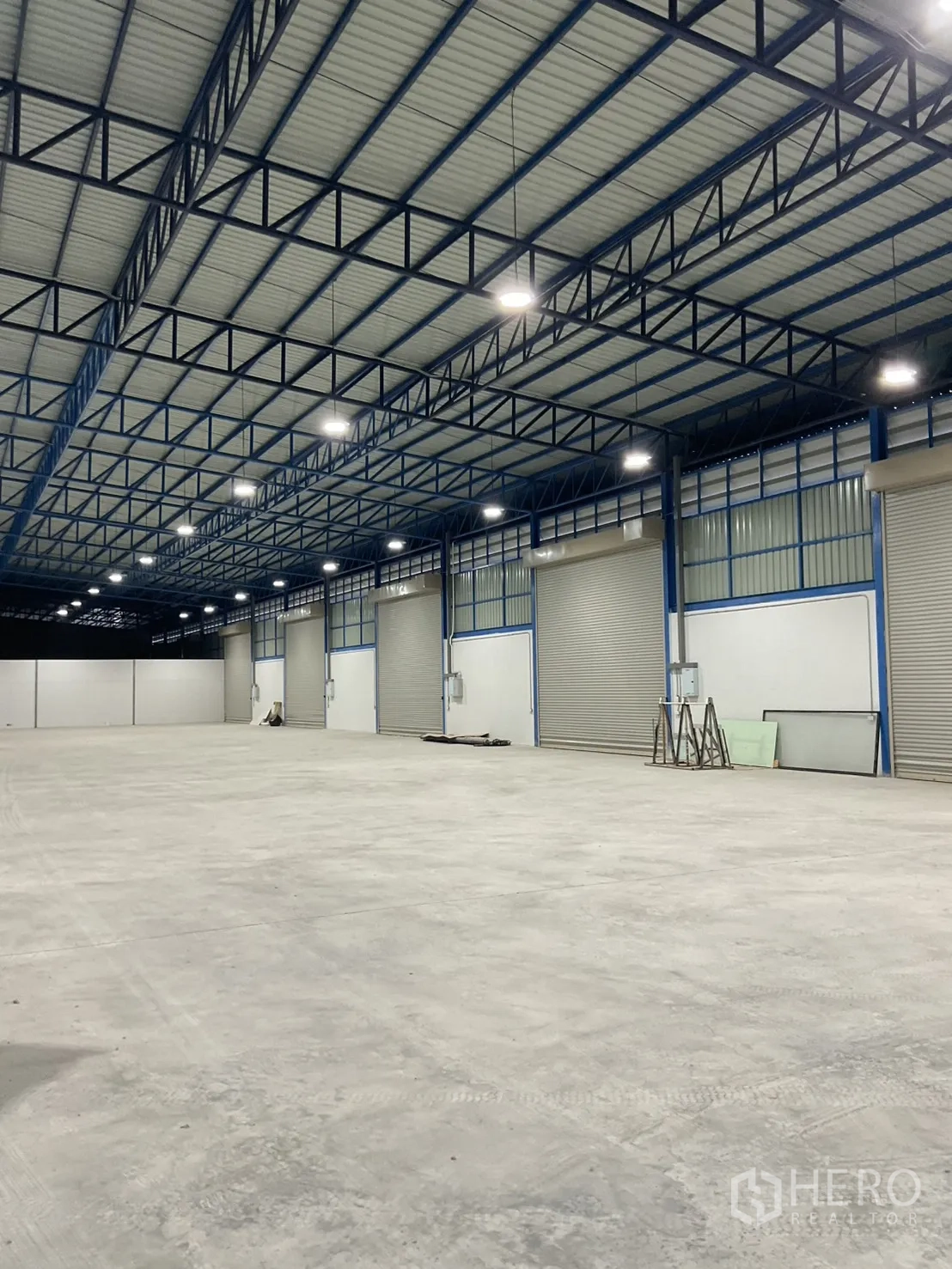 Warehouse for rent in Bang Bua Thong, Nonthaburi - Warehouse hall showing wide column-free space, insulated roof, and multiple loading doors.