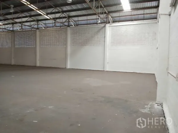 Warehouse for rent in Bang Phli, Samut Prakan - Large warehouse interior featuring high ceiling, ventilation block walls and a concrete floor.