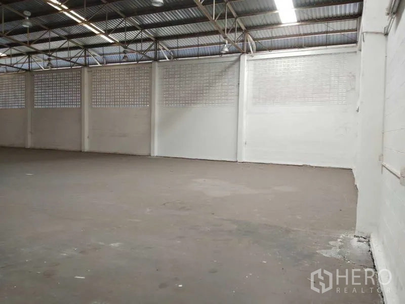 Warehouse for rent in Bang Phli, Samut Prakan - Large warehouse interior featuring high ceiling, ventilation block walls and a concrete floor.