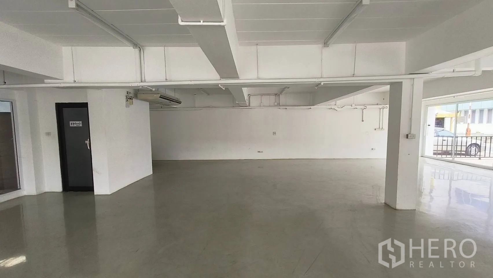 Office Space for rent in Khlong Toei, Bangkok - Spacious open-plan ground floor office with polished flooring and air-conditioning units.