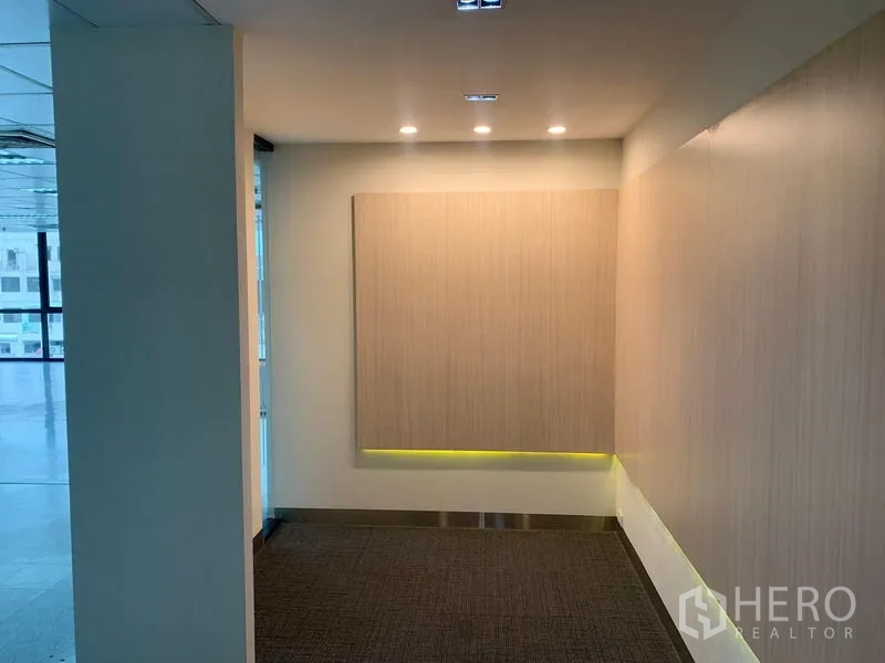 办公空间 出租在Bang Rak, Bangkok - 接待角落，木饰面背景墙与天花射灯。