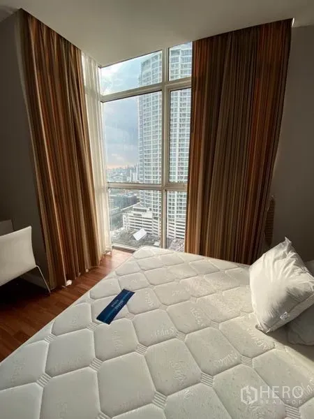 Condominium for rent in Watthana, Bangkok - Bedroom corner with floor-to-ceiling windows, striped curtains and expansive city view