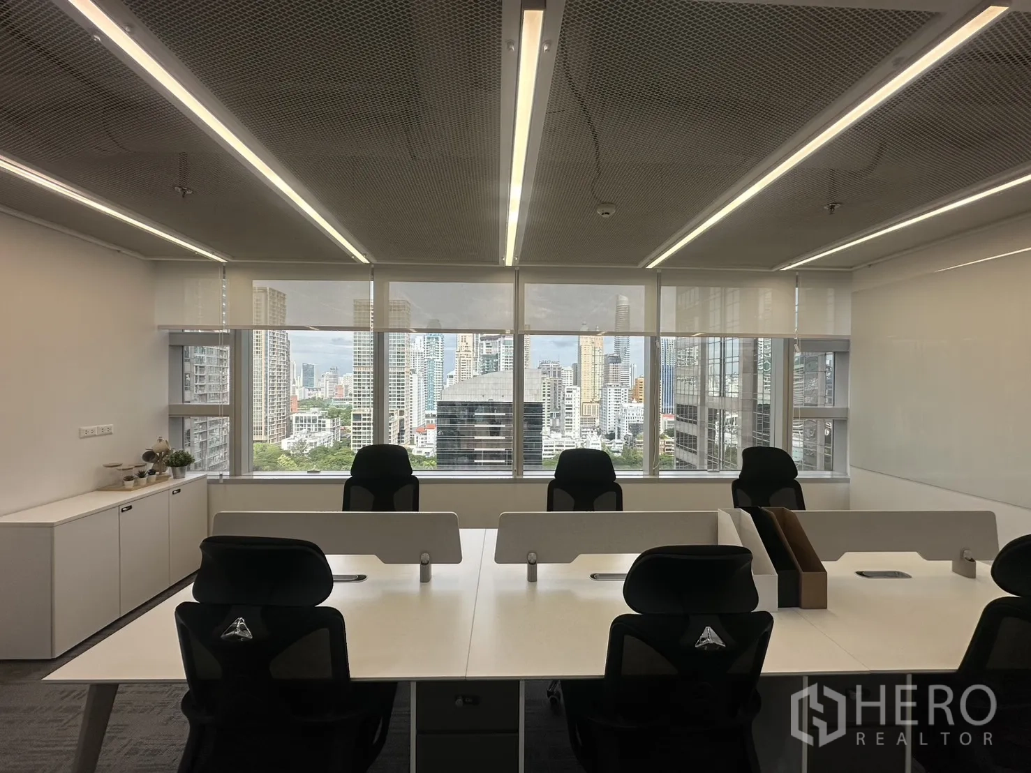办公室 for rent in Pathum Wan, Bangkok - 面向大窗的办公桌，配卷帘并享城市天际线景观。