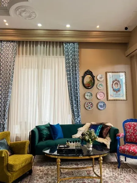 零售空间 出租在Khlong Toei, Bangkok - 客户休息区，丝绒沙发与彩色扶手椅，墙面装饰盘。