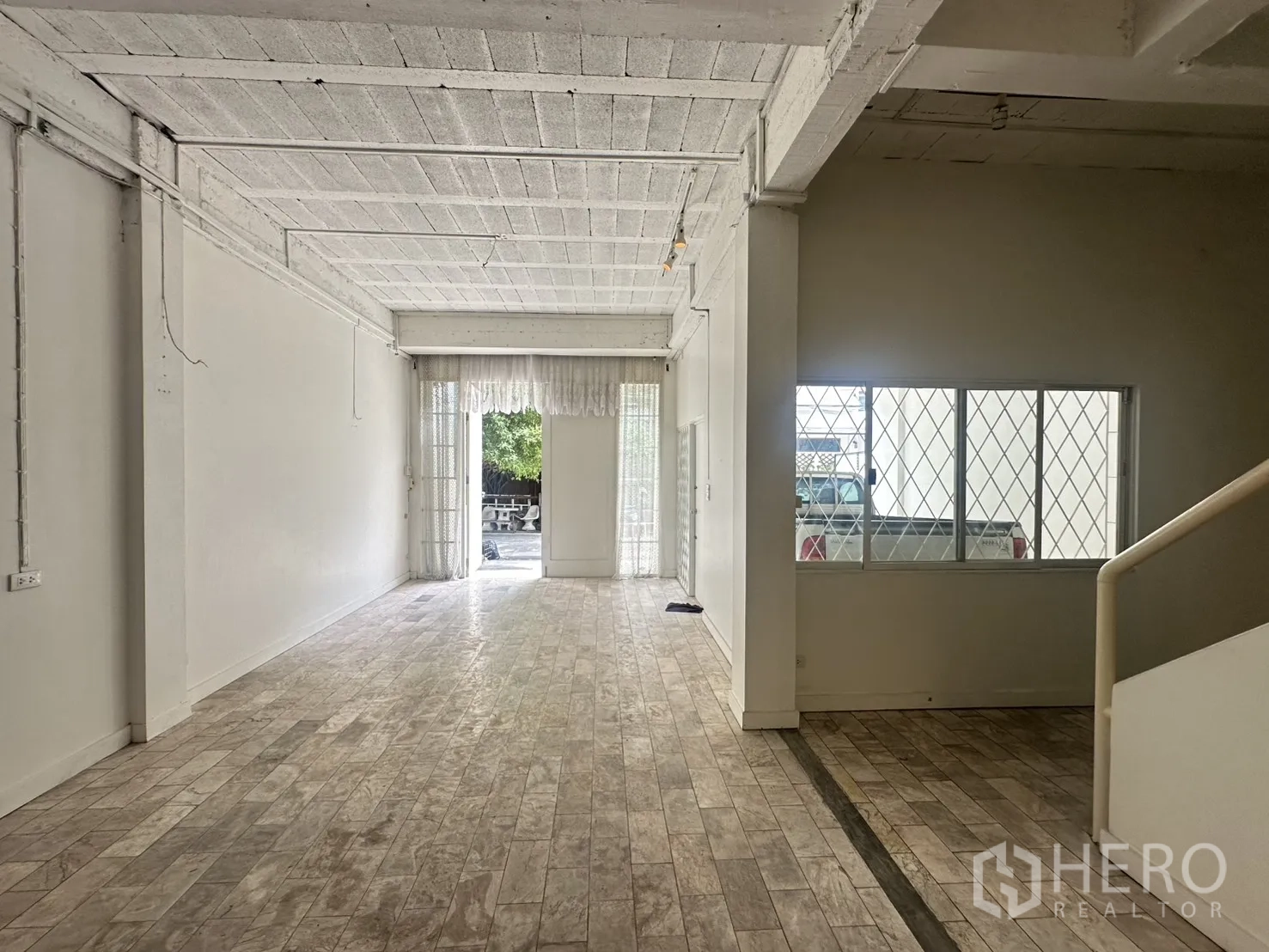Home Office for rent in Watthana, Bangkok - Long room facing the street with security-grilled windows.