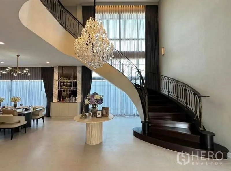 บ้าน ให้เช่าในLat Krabang, Bangkok - โถงทางเข้าหรู บันไดโค้ง โคมระย้า และพื้นที่รับประทานอาหาร