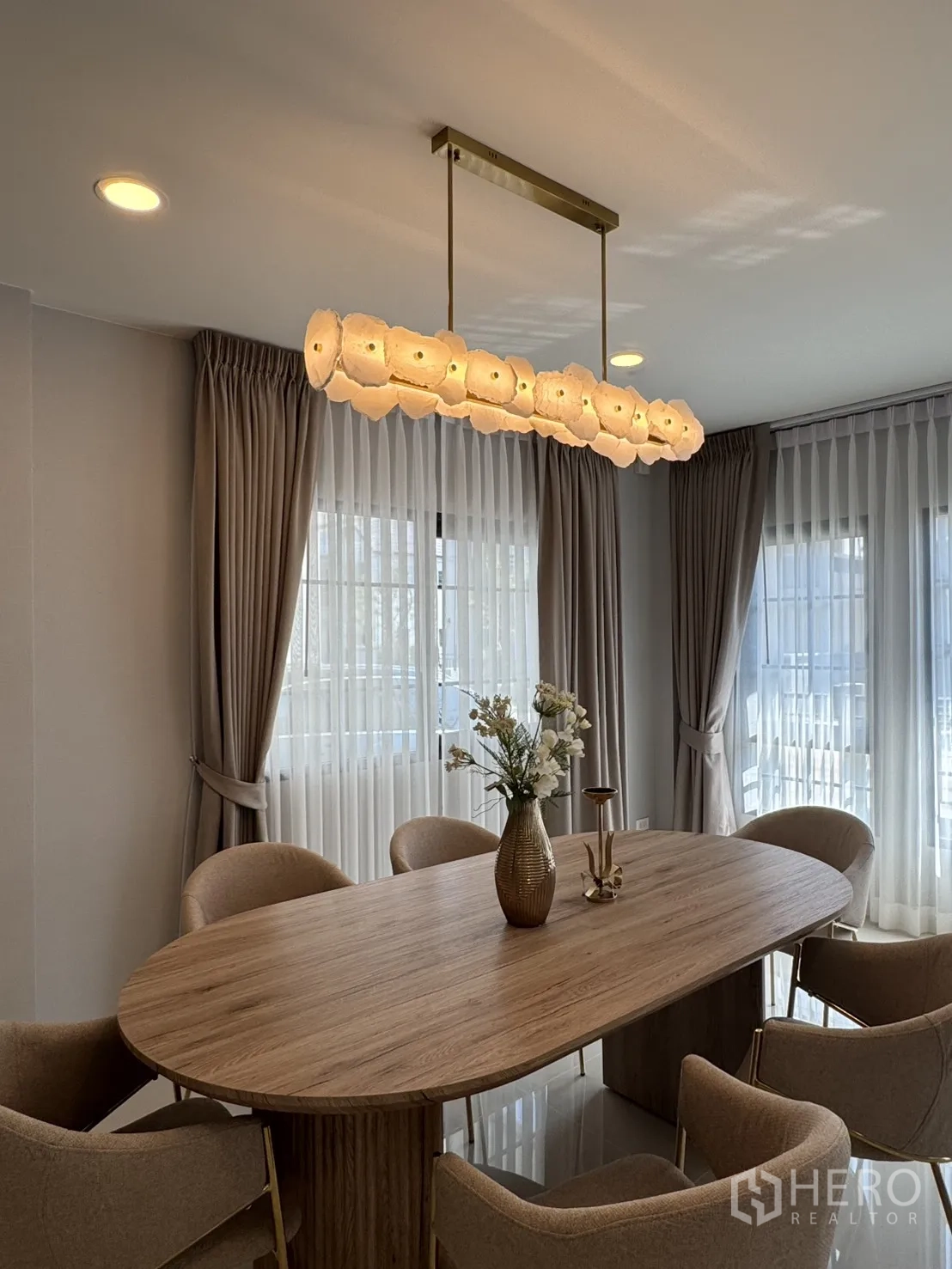 Detached House for rent in Bang Phli, Samut Prakan - Dining corner with six upholstered chairs around a wooden table under warm pendant lighting.