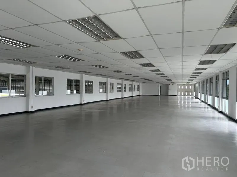 工厂 出租在Pathum Thani - 长条形开放式办公楼层，两侧采光窗。