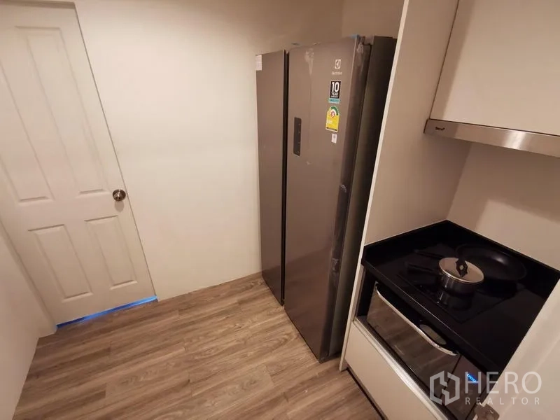 Condominium for rent or sale in Huai Khwang, Bangkok - Compact separate kitchen with side-by-side fridge and built-in cooktop.