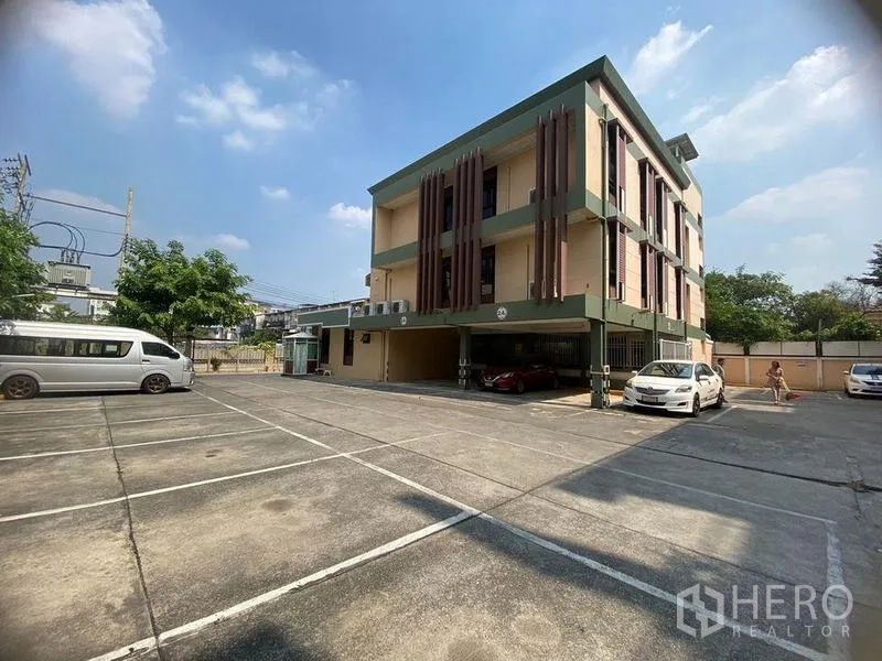 Home Office for rent in Don Mueang, Bangkok - Full view of three-storey building with a large open car park.