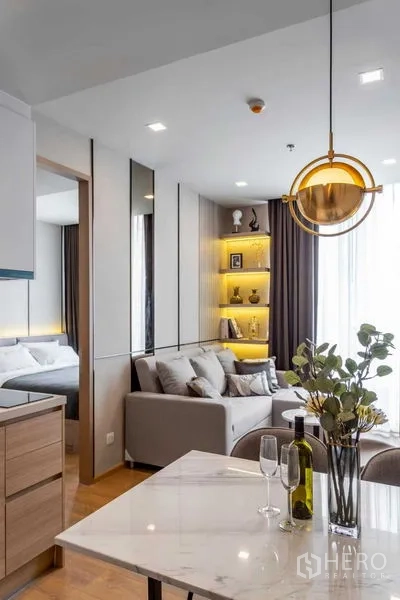 Condominium for rent in Watthana, Bangkok - Dining area with round pendant light overlooking the living room and bedroom entrance.