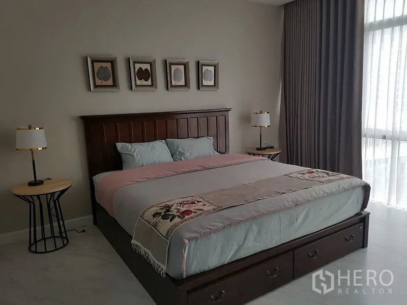 公寓 出租或出售在Bang Na, Bangkok - 主卧配特大床、床头灯、装饰画与大窗帘。