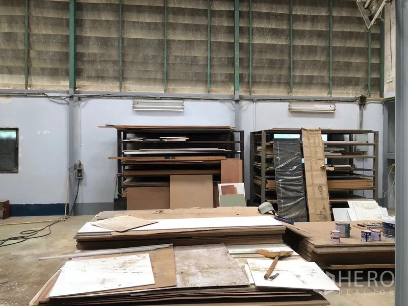 货栈 出租在Khlong Sam Wa, Bangkok - 材料货架与胶合板堆放在通风良好的仓库墙边。