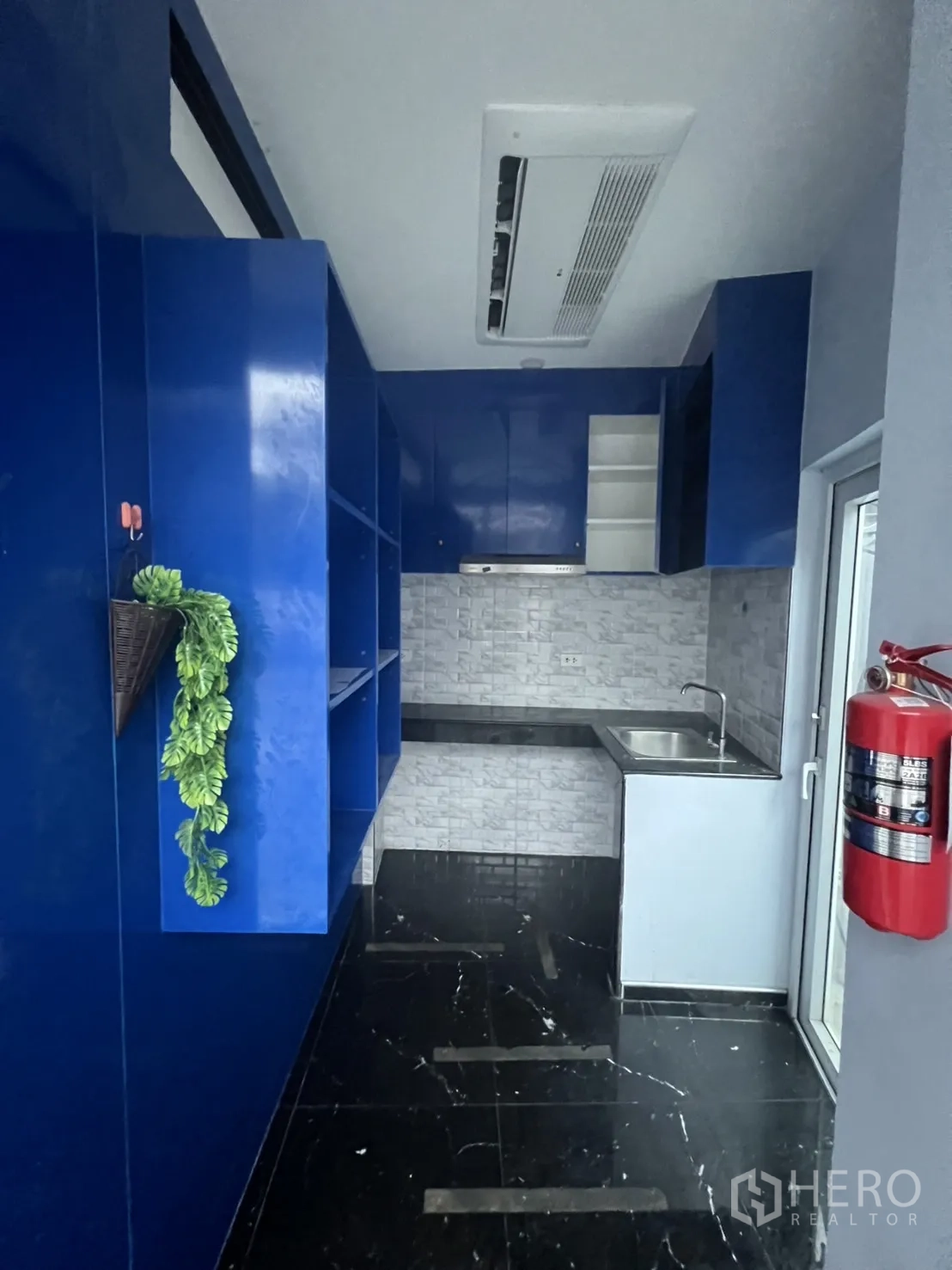 零售空间 出租在Khlong Toei, Bangkok - 后置茶水间，蓝色柜体、不锈钢水槽与吊顶空调，适合咖啡准备。