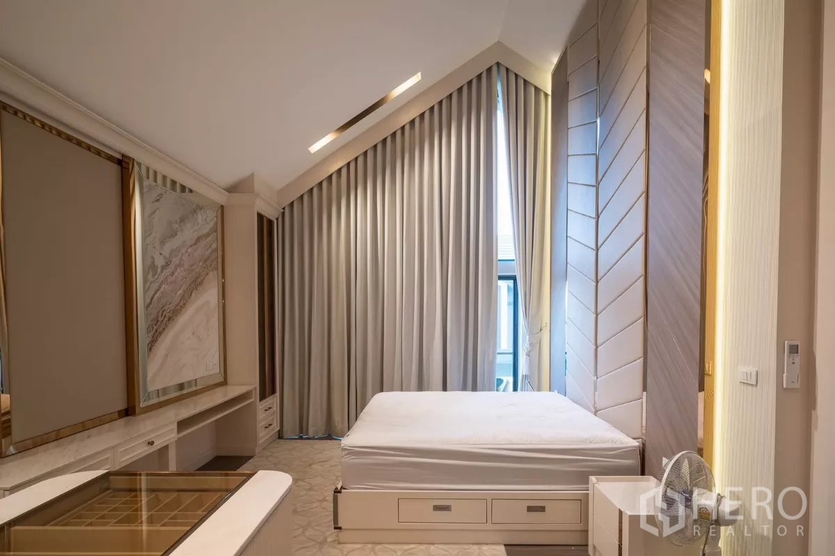 Detached House for rent or sale in Saphan Sung, Bangkok - Master bedroom with vaulted ceiling, full‑height curtains and built‑in furnishings.